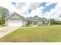 Charming single-story home featuring a well-maintained lawn and a classic two-car garage at 908 Hornbeam Ct., Loris, SC 29569