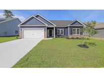Charming single-story home with a well-manicured lawn, brick accents, and a two-car garage at 115 Old Chimney Ln, Conway, SC 29526