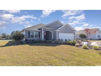 Charming single-story home featuring a two-car garage and a well-manicured lawn in a friendly neighborhood at 1224 Barrington Way, Conway, SC 29526