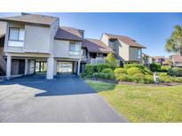Beautiful exterior view of a multi-level home with a covered parking area and lush landscaping at 124 Spartina Ct. # 30, Pawleys Island, SC 29585