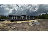 Modern manufactured home featuring a crisp exterior with dark siding and bright white window trim at 1301 Rabbit Ln., Conway, SC 29526