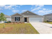 Charming single-story home with a well-manicured lawn and a two-car garage at 1406 Nokota Dr., Conway, SC 29526