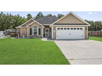 Charming single-Gathering home featuring a two-car garage and a beautifully maintained green lawn at 210 Fox Hunt Pl., Aynor, SC 29511