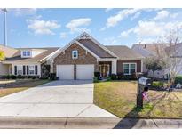 Charming single-Gathering home featuring a stone facade, two-car garage, and manicured lawn at 3672 White Wing Circle, Myrtle Beach, SC 29579