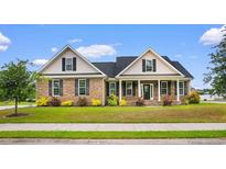 Charming brick home with manicured lawn, lush landscaping, and inviting front porch at 4067 Ridgewood Dr., Conway, SC 29526