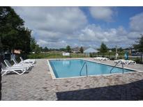 Community pool with lounge chairs, and a clear view of the neighborhood under a blue sky at 430 Lifestyle Court, Surfside Beach, SC 29575