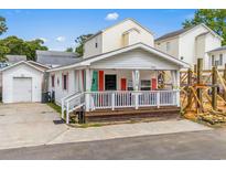 Charming beach house with a covered front porch, white siding, and red shutters at 6001- 5718 S Kings Highway, Myrtle Beach, SC 29575