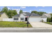 Charming single-story home featuring a well-manicured lawn, attached two car garage, and inviting curb appeal at 649 W Perry Rd., Myrtle Beach, SC 29579