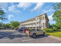 Attractive condominium building with outside staircases and parking on a sunny day at 683 Riverwalk Dr. # 302, Myrtle Beach, SC 29579