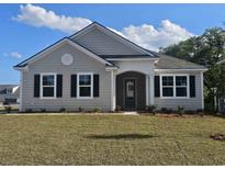 Charming single-story home with light gray siding, black shutters, and a well-maintained lawn on a sunny day at 725 Choctaw Dr., Conway, SC 29526
