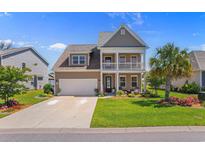 Charming two-story home featuring a welcoming front porch, well-manicured lawn, and beautiful landscaping at 808 Atlantic Commons Dr., Surfside Beach, SC 29575