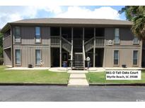 Inviting condo with two-story facade, accessed by a central staircase and featuring wood-look siding and verdant lawn at 861 Tall Oaks Ct. # D-61, Myrtle Beach, SC 29588