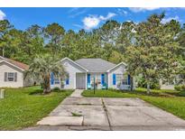Charming single-story home with a well-maintained lawn, quaint blue shutters, and a welcoming walkway to the front door at 9450 Leeds Circle, Myrtle Beach, SC 29588
