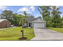 Charming single-story home with a well-maintained lawn, gray siding, and attached two-car garage at 103 Teal Ct., Myrtle Beach, SC 29588