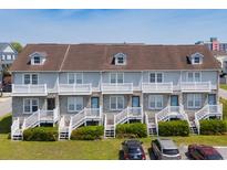 Aerial view of a grey, multi-Gathering townhouse complex with white stairs and trim at 112 3Rd Ave. S # B, Surfside Beach, SC 29575