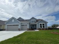 Charming two-story home with blue siding, dual garage doors, and a well-manicured front lawn at 1430 Crested Iris Way, North Myrtle Beach, SC 29582