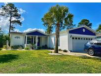 Charming white home with blue trim, a well-manicured lawn and beautiful landscaping including a palm tree at 1755 Fairbanks Dr., Conway, SC 29526
