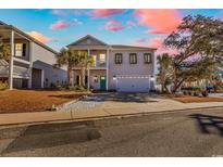 Inviting two-story home with covered porch, palm trees, and a two-car garage at 226 9Th Ave. S, North Myrtle Beach, SC 29582