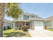 Charming two-story home features a landscaped yard, garage, and inviting entrance at 232 Palm Cove Circle, Myrtle Beach, SC 29588