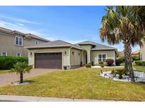 Charming single-story home featuring a well-manicured lawn, brown two-car garage, and tasteful landscaping at 274 Avenue Of The Palms, Myrtle Beach, SC 29579