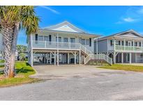 Charming raised beach house with white railings and ample ground-level parking at 414 32Nd Ave. N, North Myrtle Beach, SC 29582