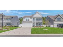 Charming two-story home with a white exterior, landscaped front yard, and a two-car garage at 456 Cattle Drive Circle, Myrtle Beach, SC 29588