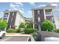 Well-maintained condo building with brick facade, green shutters, and landscaped grounds at 488 River Oaks Dr. # 61F, Myrtle Beach, SC 29579