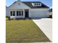 Charming single-story home with a well-maintained lawn, covered porch, and attached two-car garage at 527 Magnolia Terrace Dr, Myrtle Beach, SC 29579