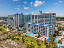 Expansive aerial view of a beachfront resort featuring multiple pools, palm trees, and inviting ocean access at 5300 N Ocean Blvd. # 422, Myrtle Beach, SC 29572