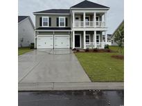 Charming two-story home with a double garage, inviting front porch, and well-maintained lawn at 532 Magnolia Terrace Dr, Myrtle Beach, SC 29579