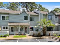 Inviting townhome exterior with a tidy lawn, mature trees, and reserved parking spaces in a desirable neighborhood at 55 Shadow Moss Pl. # 55, North Myrtle Beach, SC 29582