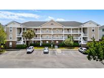 Charming condo complex with multiple stories, white balconies, well-maintained landscaping and convenient parking spaces at 5751 Oyster Catcher Dr. # 334, North Myrtle Beach, SC 29582