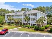 Beautiful three-story condo building with palm trees, landscaping, and private balconies at 6253 Catalina Dr. # 422, North Myrtle Beach, SC 29582