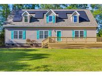 Charming home featuring solar panels, a large deck, and teal shutters, enhancing its curb appeal at 6357 Highway 707, Myrtle Beach, SC 29588