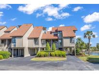 Beautiful exterior of this townhome featuring manicured landscaping and ample parking with water views at 66 Lakeview Circle # 106, Pawleys Island, SC 29585