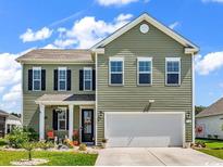 Charming two-story home with a well-manicured lawn and inviting front porch at 732 Mustang Ranch Dr., Myrtle Beach, SC 29588