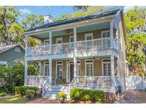 Charming two-story home with a double front porch and inviting outdoor seating area at 99 Berry Tree Dr., Pawleys Island, SC 29585
