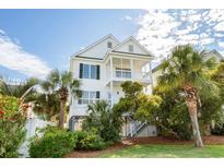 Charming two-story white home with double balconies and lush tropical landscaping at 113A 9Th Ave. S, Surfside Beach, SC 29575