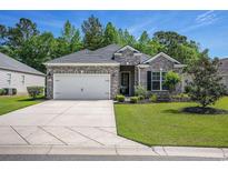 Charming brick home featuring an attached garage and a well-manicured lawn at 1434 Chanson Ct., Little River, SC 29566