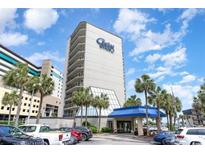 An attractive exterior view of the Carolina Winds Resort building with palm trees and a blue sky background at 200 76Th Ave. N # 301, Myrtle Beach, SC 29572