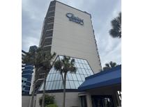 Exterior shot of the building with palm trees and blue Carolina Winds signage against a cloudy sky at 200 76Th Ave. N # 608, Myrtle Beach, SC 29572