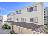 Charming multi-level townhouse with cream siding, dark window trim, and nicely maintained brick pathway at 209 75Th Ave N # T-8, Myrtle Beach, SC 29572