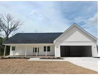 Charming single-story home featuring a covered porch, attached two-car garage and neutral color palette at 357 Log Cabin Rd., Loris, SC 29569