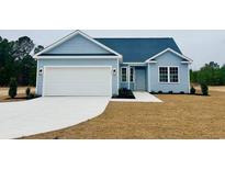 Charming single-story home featuring light blue siding, a two-car garage, and manicured front lawn at 375 Log Cabin Rd., Loris, SC 29569