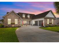 Beautiful single Gathering home featuring stone accents, dormer windows and a two-car garage at dusk at 400 Palo Verde Dr., Myrtle Beach, SC 29579