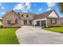 Charming home featuring stone accents, a three-car garage, and a well-manicured lawn at 400 Palo Verde Dr., Myrtle Beach, SC 29579