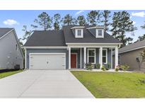 Charming single-Gathering home featuring blue siding, dormer windows and a two-car garage at 452 Sun Colony Blvd., Longs, SC 29568