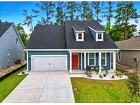 Charming blue home featuring a two-car garage, landscaped front yard, and an inviting red front door at 452 Sun Colony Blvd., Longs, SC 29568