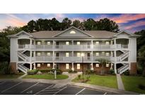 Well-maintained condo building features multiple floors and private balconies, surrounded by lush landscaping and a paved parking lot at 5750 Oyster Catcher Dr. # 333, North Myrtle Beach, SC 29582
