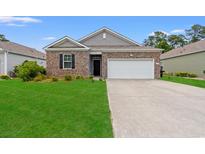 Charming brick home with a well-manicured lawn and a two-car garage at 662 Wallace Dr., Little River, SC 29566